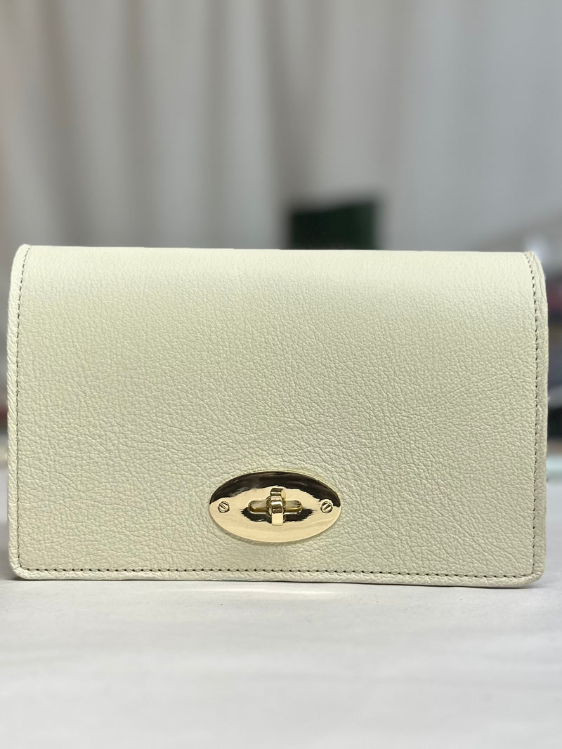 The Luna bag front with gold twist lock in cream leather
